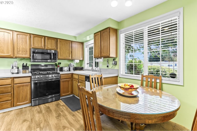 1018 S Holly Ct, Canby, OR 97013 - kitchen featuring stainless steel appliances, light countertops, light wood-style flooring, and brown cabinetry