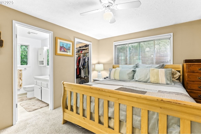 1018 S Holly Ct, Canby, OR 97013 - bedroom with a spacious closet, a closet, ensuite bath, ceiling fan, and a textured ceiling