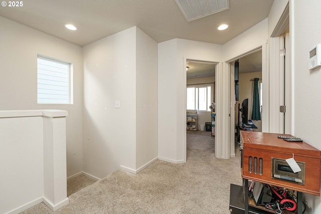 hallway with light colored carpet