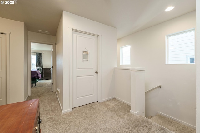 hallway featuring light colored carpet