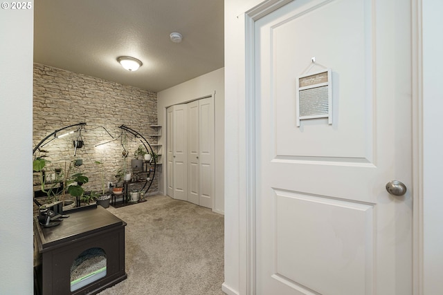 corridor featuring light colored carpet and a textured ceiling