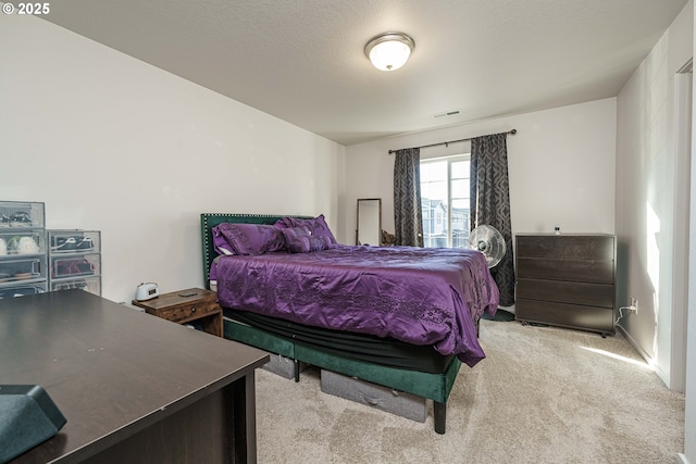 bedroom featuring light carpet and a textured ceiling