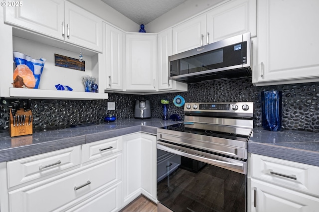 35363 Woodland Ln, Astoria, OR 97103 - kitchen featuring white cabinets, dark countertops, and stainless steel appliances