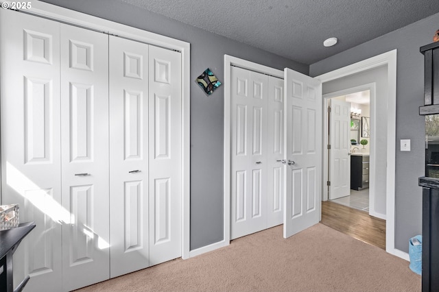 35363 Woodland Ln, Astoria, OR 97103 - unfurnished bedroom featuring carpet floors, baseboards, two closets, and a textured ceiling