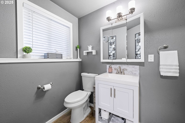 35363 Woodland Ln, Astoria, OR 97103 - half bathroom featuring vanity, toilet, and wood finished floors