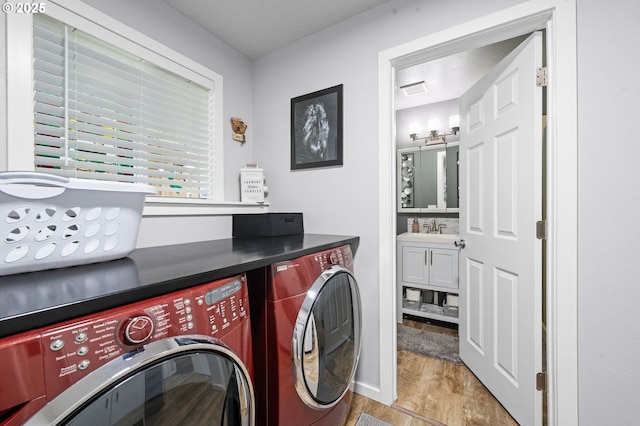 35363 Woodland Ln, Astoria, OR 97103 - laundry room featuring laundry area, light wood-style floors, visible vents, a sink, and washing machine and dryer