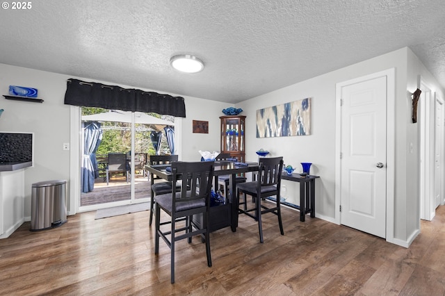 35363 Woodland Ln, Astoria, OR 97103 - dining room with baseboards, wood finished floors, and a textured ceiling