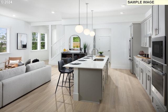 11855 SW Bosley Ter, Beaverton, OR 97007 - kitchen featuring gray cabinetry, stainless steel appliances, open floor plan, light countertops, and a breakfast bar
