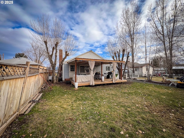 back of property with a lawn and a deck