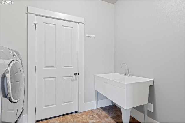 clothes washing area featuring washer / dryer and sink