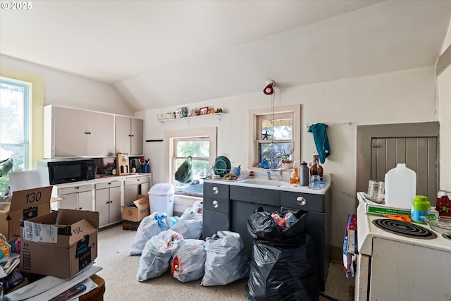 490 W 4th Ave, Eugene, OR 97401 - kitchen with black microwave, light countertops, vaulted ceiling, white cabinetry, and white electric stove
