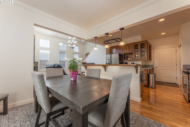 dining area with recessed lighting, ornamental molding, a chandelier, and light wood-style flooring