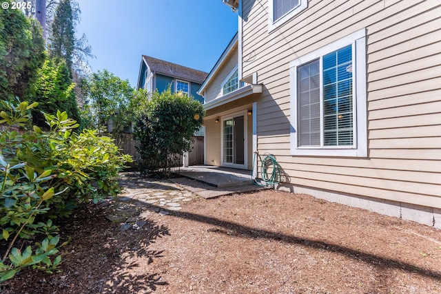 property entrance featuring fence and a patio