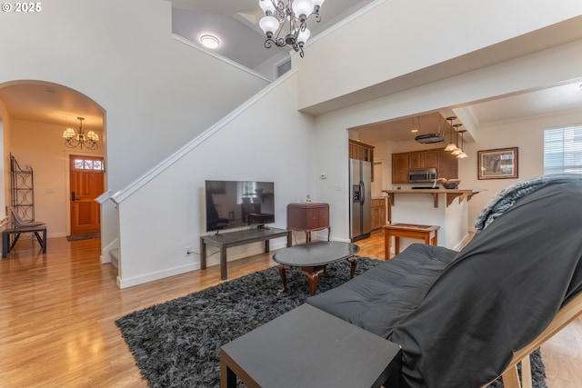 living room featuring stairway, an inviting chandelier, visible vents, and light wood finished floors