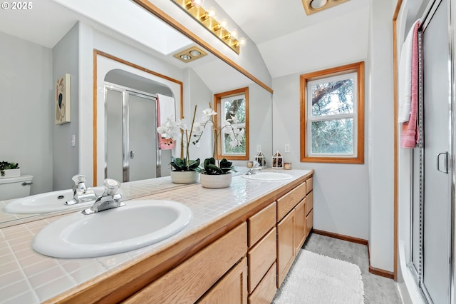 3870 Ashford Dr, Eugene, OR 97405 - bathroom featuring a stall shower, double vanity, vaulted ceiling, toilet, and baseboards