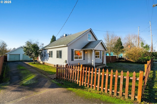 bungalow-style home with a front yard, a garage, and an outdoor structure