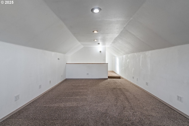 bonus room with lofted ceiling, a textured ceiling, and carpet flooring