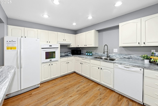 4460 SW Scholls Ferry Rd Unit 5, Portland, OR 97225 - kitchen with white appliances, under cabinet range hood, light wood-type flooring, white cabinetry, and recessed lighting