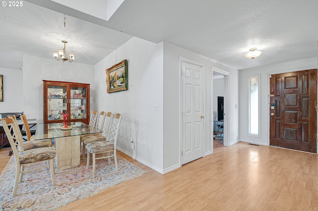 8670 SW Indian Hill Ln, Beaverton, OR 97008 - dining area with a chandelier, light wood finished floors, and a textured ceiling