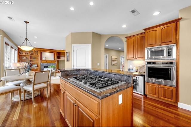 kitchen with stainless steel appliances, wine cooler, a kitchen island, and visible vents