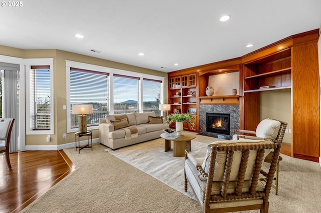 living area with a high end fireplace, recessed lighting, visible vents, and baseboards