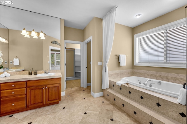 bathroom featuring baseboards, tile patterned floors, a spacious closet, vanity, and a bath