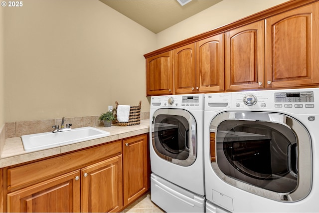 clothes washing area featuring cabinet space, washer and clothes dryer, and a sink