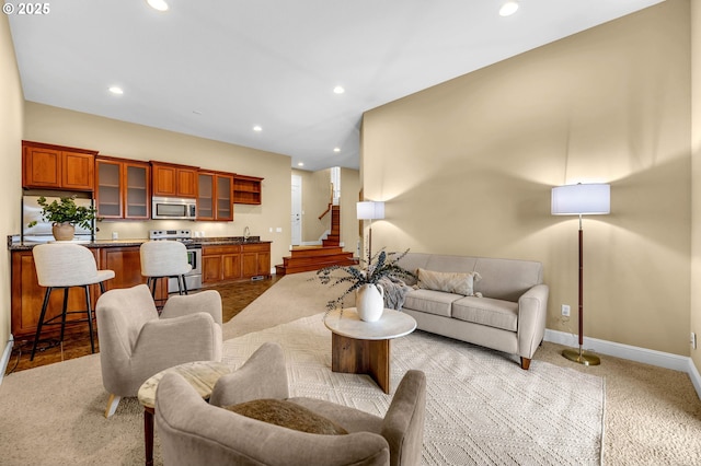 living room featuring baseboards, stairway, light carpet, and recessed lighting