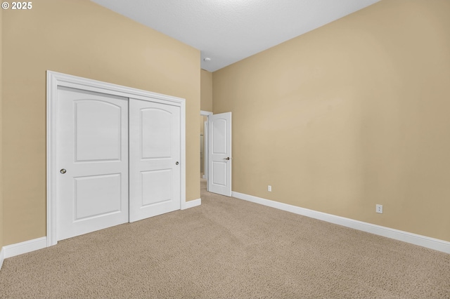 unfurnished bedroom with carpet, baseboards, and a closet