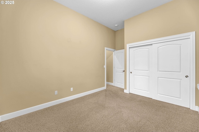 unfurnished bedroom with carpet floors, a closet, and baseboards