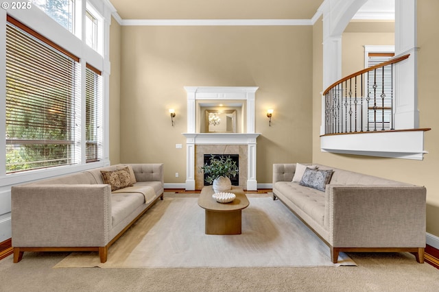 living area featuring arched walkways, crown molding, a fireplace, a towering ceiling, and baseboards