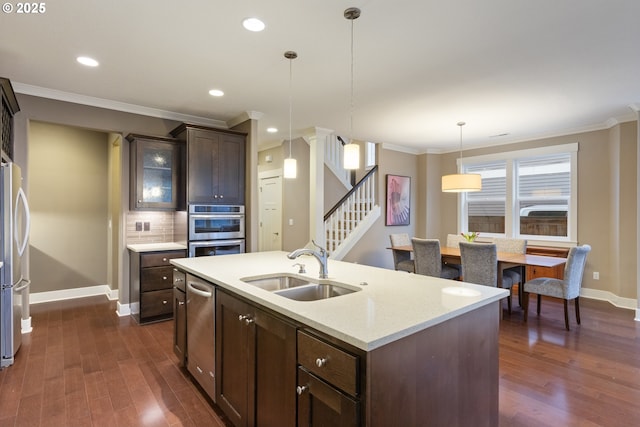 kitchen with dark brown cabinets, hanging light fixtures, sink, ornamental molding, and decorative backsplash