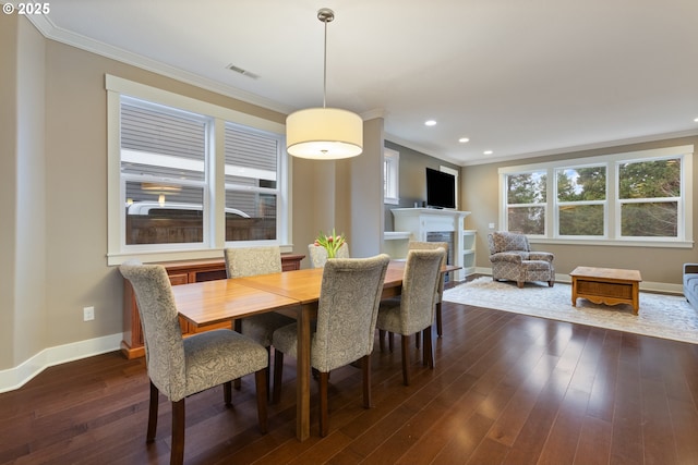 dining space with dark hardwood / wood-style flooring and ornamental molding