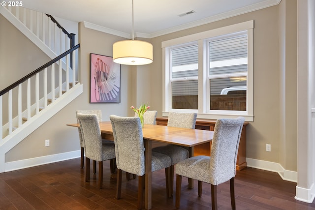 dining space featuring dark hardwood / wood-style flooring and ornamental molding