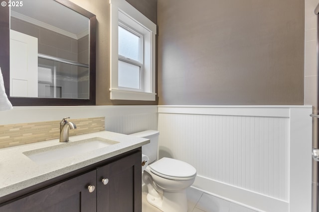 bathroom featuring toilet, an enclosed shower, tile patterned floors, ornamental molding, and vanity