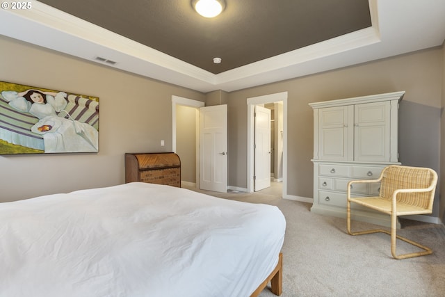 bedroom featuring light carpet and a raised ceiling