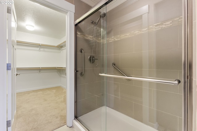 bathroom featuring a textured ceiling and walk in shower