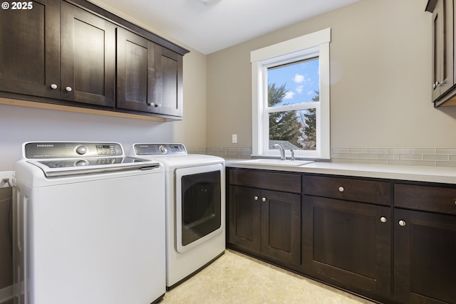 laundry room with sink, cabinets, and washer and clothes dryer