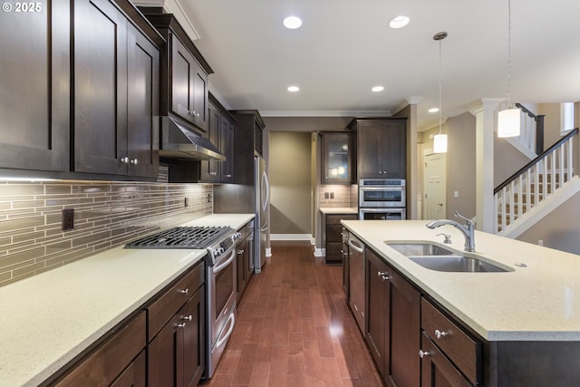 kitchen with pendant lighting, appliances with stainless steel finishes, sink, backsplash, and dark hardwood / wood-style floors