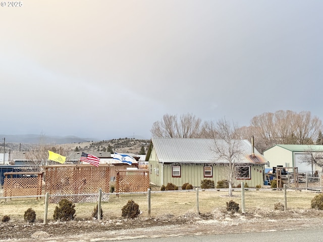 view of front of property with metal roof, a fenced front yard, and board and batten siding
