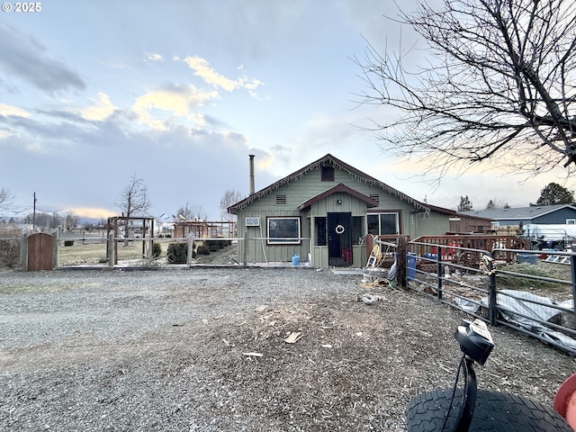view of front of house with board and batten siding, a gate, and fence