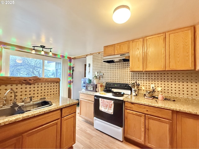 kitchen with white electric stove, light wood-style flooring, a sink, under cabinet range hood, and backsplash