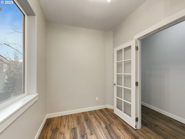 unfurnished room featuring a textured ceiling and dark hardwood / wood-style floors