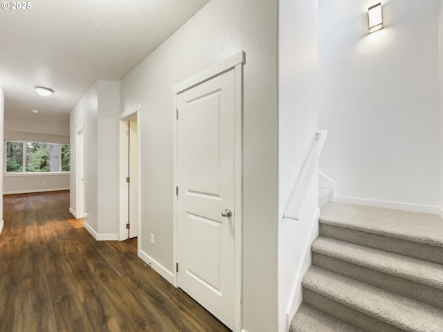 hall with dark hardwood / wood-style flooring and a textured ceiling