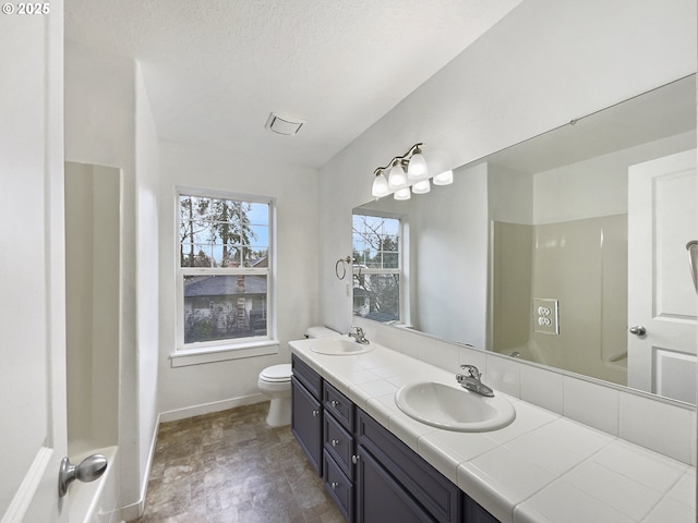 bathroom featuring a textured ceiling, vanity, and toilet