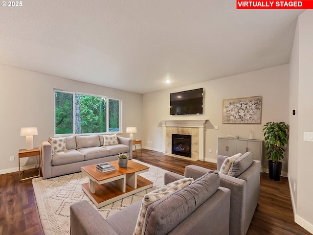 living room with a tile fireplace and hardwood / wood-style flooring