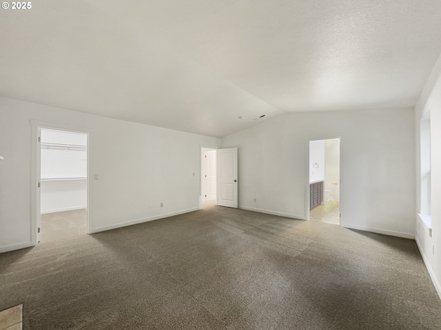 carpeted empty room featuring a wealth of natural light and lofted ceiling