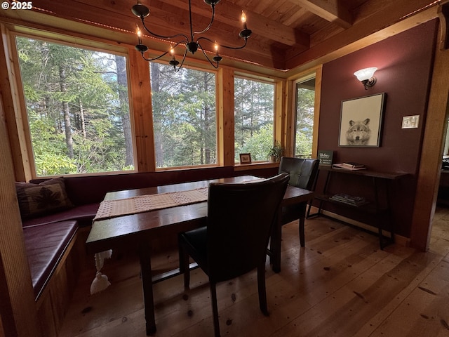 dining area featuring an inviting chandelier, hardwood / wood-style floors, breakfast area, wooden ceiling, and beamed ceiling