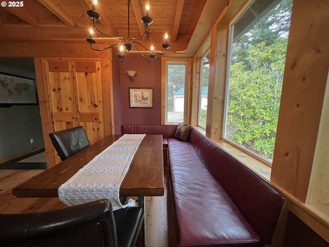 dining room with a notable chandelier, beam ceiling, and wooden ceiling