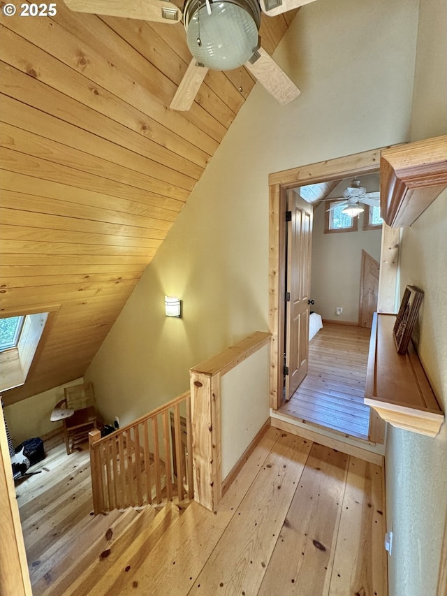 bonus room with ceiling fan, vaulted ceiling with skylight, wooden ceiling, and light wood-type flooring